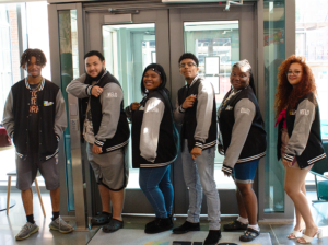 Group of 6 teens pose with letterman jackets