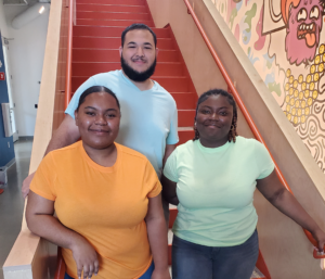 Three students by mural