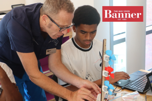 Educator and student work on building a mini wind turbine