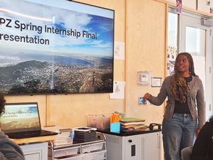 Student standing in front of a slide, presenting