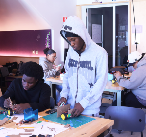 Four students building robotic vehicle prototypes